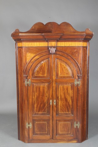 A Georgian inlaid mahogany corner cabinet with raised back, moulded and dentil cornice, the interior fitted 3 shaped shelves, the base with 3 spice drawers enclosed by a pair of arched panelled doors 62"h x 28"w x 37"d 