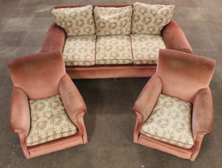 A 1930's Art Deco 3 seat settee with scroll shaped arms upholstered in rose pink dralon 30"h together with a pair of armchairs
