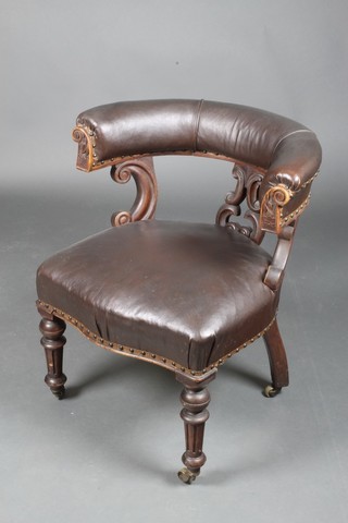 A Victorian carved walnut show frame tub back office chair raised on turned and fluted supports  