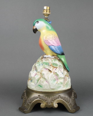 A gilt metal mounted lamp base with a porcelain figure a parrot seated on a rocky outcrop 14" 