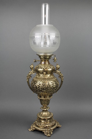 A handsome Victorian pierced brass oil lamp in the form of a twin handled urn with chimney and etched glass shade, raised on a circular foot, 32"h 