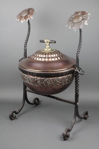 A Victorian circular repousse copper and wrought iron coal bin, the brass and turned ebony handle in the form of a claw clenching a rod, the bucket raised on a wrought iron stand and with sunflower finials 29"h 