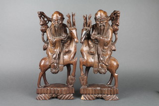 A pair of 19th Century Japanese carved and pierced hardwood figures of mounted deities on stags, with hardstone eyes,  15"  
