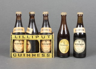 A paper crate containing 3 miniature bottles of Guinness together with 2 miniature bottles of Guinness 