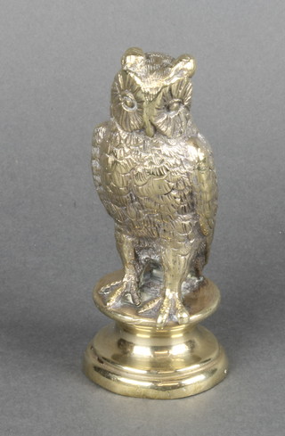 A 19th Century brass finial in the form of a standing owl, raised on a circular base 