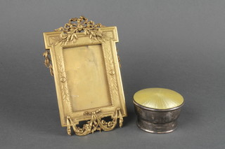 A gilt ormolu photograph frame decorated swags 6 1/2" x 4" together with a circular silver and yellow enamelled dressing table jar lid 