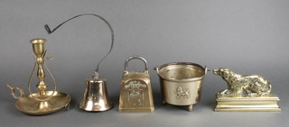 A 19th Century brass service bell with iron spring, brass doorstop in the form of a dog 6", a circular brass cauldron decorated walking lion and marked 1521 4 1/2", a Continental square brass cow bell and a reproduction brass gimbaled chamber stick