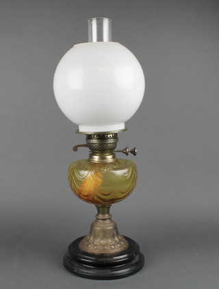 A glass oil lamp reservoir raised on embossed metal base with opaque shade and clear glass chimney 21" 