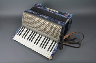 A Hohner Carmen 2 accordion with 24 buttons, contained in a blue marble effect case  