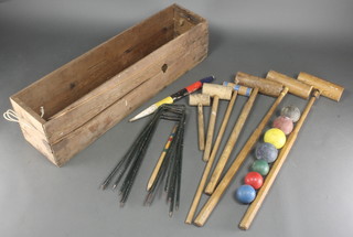 A croquet set comprising 3 wooden mallets, peg, 4 turned wooden balls, 6 metal hoops together with 2 childs croquet mallets, stick and 3 ball, contained in a wooden box 
