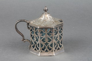 A mid Victorian octagonal chased and pierced silver mustard pot with S scroll handle, London 1842