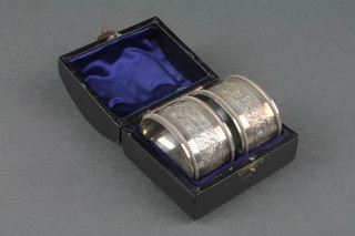 A cased pair of Victorian silver engraved napkin rings, Birmingham 1894 