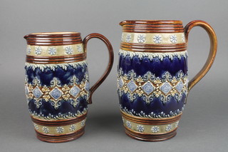 2 Doulton Lambeth cylindrical jugs, the blue ground with a band of geometric decoration no.9583 10" and 9" 