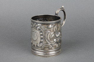 A 19th Century American repousse silver mug decorated with fruits, flowers and scrolls, with engraved inscription 1868