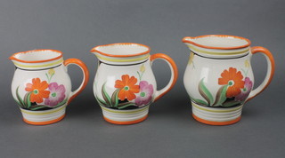A set of 3 Art Deco graduated jugs decorated with flowers