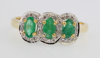 A 14ct yellow gold emerald and diamond triple cluster ring, size M