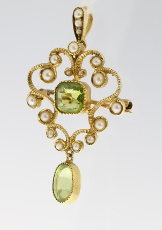 An Edwardian 15ct peridot and seed pearl open scroll brooch 