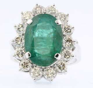 A 14ct white gold emerald and diamond cluster ring, the centre stone approx 8.5ct surrounded by 14 brilliant cut diamonds approx. 2.55ct, size R 