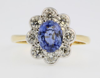 An 18ct yellow gold oval sapphire and diamond cluster ring, the centre stone approx. 0.80ct surrounded by 8 brilliant cut diamonds 1.30ct, size 0 1/2
