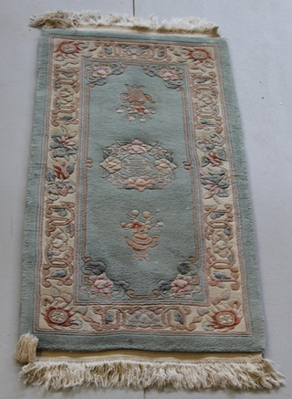 A green ground and floral patterned Chinese rug 52" x 24", some light staining 