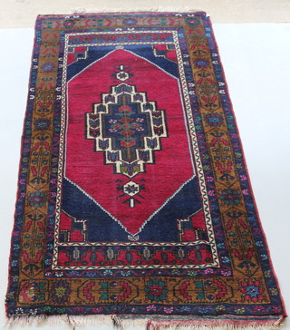 A blue ground Afghan rug with stylised diamonds to the centre 99" x 48" 