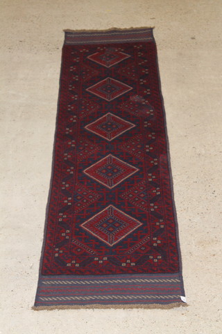 A red ground Meshwani runner with 5 diamonds to the centre 108" x 24 1/2" 