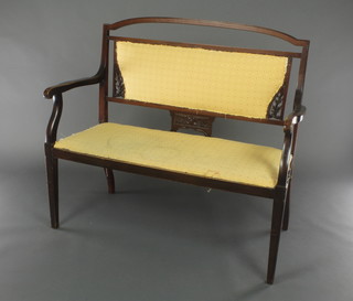 An Edwardian Art Nouveau pierced and carved walnut double chair back settee, raised on square tapering supports 