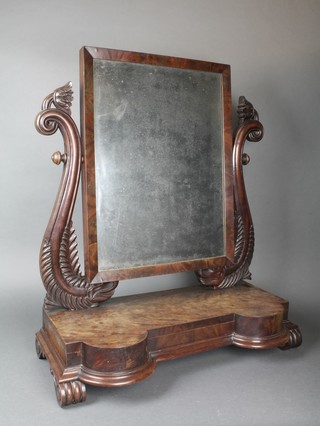 A William IV rectangular plate dressing table mirror contained in a mahogany swing frame, the base of serpentine outline raised on scroll supports 31 1/2"h x 27"w x 12"d 