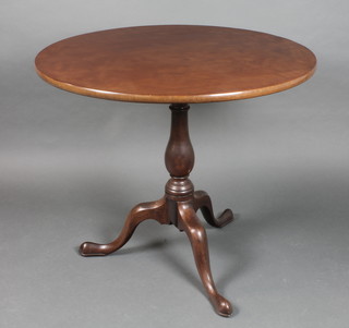 A 19th Century circular mahogany snap top tea table, raised on turned column and tripod base 27 1/2"h x 31" diam. 
