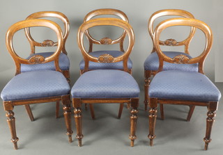 A set of 6 mahogany balloon back dining chairs with carved mid rails and upholstered seats, raised on turned supports 