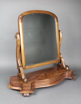 A Victorian arched plate dressing table mirror contained in a mahogany swing frame, the base of serpentine outline, raised on scroll supports 27"h x 27"w x 11"d 