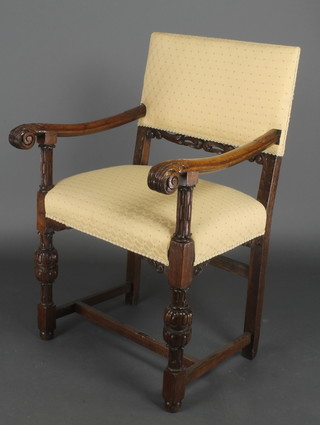 A Victorian carved oak Cromwellian style carver chair with upholstered seat and back, raised on turned supports with H framed stretcher