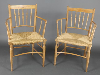 A pair of William Morris style Sussex elm open arm chairs with woven rush seats