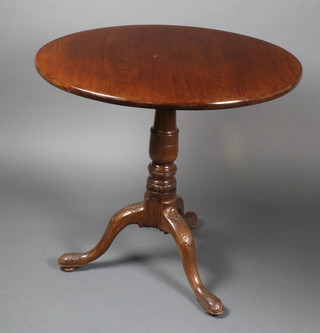 A 19th Century circular mahogany snap top tea table, raised on a turned column and carved tripod base 27 1/2"h x 29 1/2" diam.  