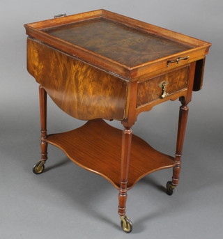 A 1930's figured walnut 2 tier drop flap drinks trolley, the upper section fitted a detachable tray and raised on turned supports, fitted a drawer, 28"h x 24"w x 17 1/2" when closed x 35" when fully extended