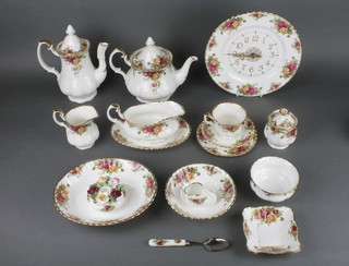 A Royal Albert Old Country Roses tea and dinner service comprising 14 tea cups, 14 saucers, 14 tea plates, 8 dessert bowls, a preserve pot and cover, a dish, a swan table ornament, a plated jam spoon, 2 teapots, 2 coffee pots, 2 milk jugs, a 3 section cake stand, a candle base, sauce boat and stand, sugar bowl, clock, 3 serving dishes and 14 dinner plates 