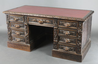 A Victorian carved oak kneehole desk with inset leather writing surface, above 1 long and 8 short drawers, with carved vinery decoration 29"h x 59"w x 29"d (in one section) 