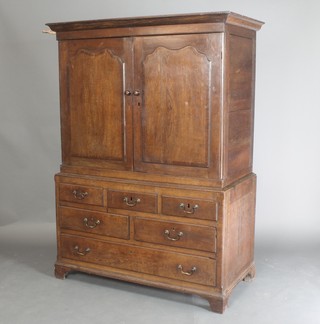 An 18th Century oak press cabinet, the upper section with moulded cornice, fitted 3 trays enclosed by arch panelled doors, the base fitted 3 short drawers above 3 long drawers 66"h x 49"w x 25"d 