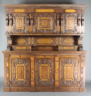 A 19th Century Continental carved and inlaid walnut sideboard chiffonier, the upper section with carved, moulded and dentil cornice, fitted 3 cupboards enclosed by panelled doors, the base with niche fitted 2 short and 2 long drawers, the base fitted 3 long drawers above cupboards enclosed by carved panelled doors 81"h x 79"w x 22"d  