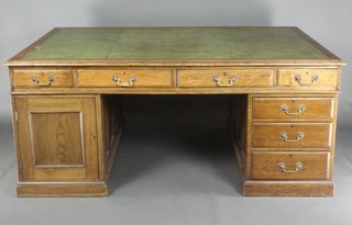 A Victorian oak pedestal partners desk with inset green writing surface above 1 long and 8 short drawers fitted cupboards and raised on a platform base 39"h x 68w x 47"d 