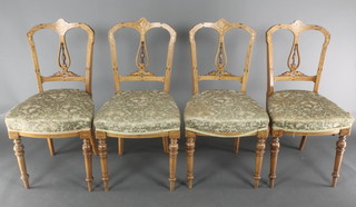 A set of 4 Victorian inlaid figured walnut dining chairs with pierced vase shaped slat backs and over stuffed seats, raised on turned supports 