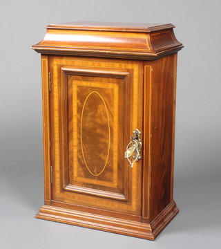 An Edwardian inlaid mahogany cabinet with shaped top, fitted a shelf enclosed by a panelled door, raised on a platform base 22"h x 14"w x 9"d 