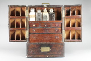 Thomson of London, a Victorian mahogany apothecaries cabinet enclosed by panelled doors, the interior revealing 18 compartments to the side, the centre section fitted 3 short and 2 long drawers, the base with drawer and with poison drawer to the back 18"h x 13"w x 9"d  