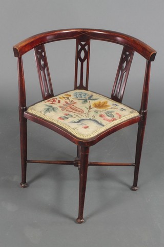 An Edwardian inlaid mahogany corner chair with pierced slat back, the seat upholstered in Berlin woolwork tapestry, raised on turned supports with X framed stretcher 