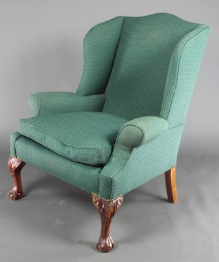 A Georgian style armchair upholstered in green material, raised on cabriole supports 