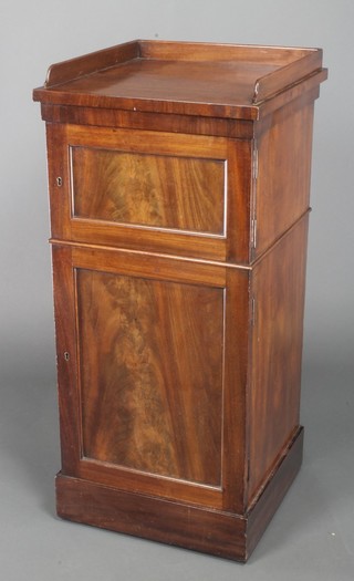 A Georgian mahogany bedside cabinet with three-quarter gallery fitted 2 cupboards enclosed by panelled doors, raised on a platform base 37"h x 17"d x 17"w 