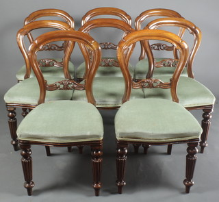 A set of 8 Victorian style mahogany balloon back dining chairs with carved mid rails, the seats of serpentine outline, raised on turned and reeded supports 