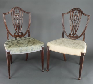 A pair of mahogany Hepplewhite style shield back dining chairs with over stuffed seats, raised on square tapering supports