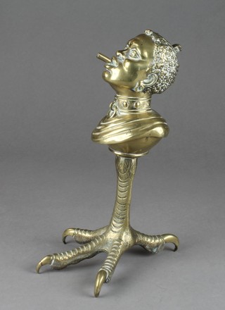 A 19th Century brass table top cigarette lighter in the form of a slaves head on a bird foot base 9 1/2"h