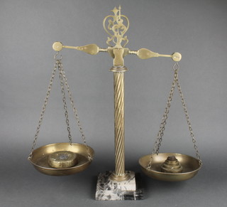 A pair of brass pan scales raised on a brass spiral column with marble stepped base complete with weights